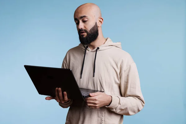 Poważny Arabski Mężczyzna Trzymający Laptopa Uczestniczący Wideokonferencji Online Młoda Łysa — Zdjęcie stockowe