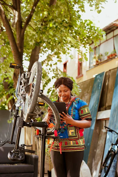 Enerjik Hevesli Siyah Kadın Evdeki Dijital Tableti Kullanarak Çeşitli Bisiklet — Stok fotoğraf