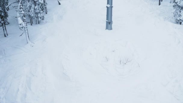 山顶上积雪覆盖的滑雪场拍摄的自上而下的镜头 上面点缀着结冰的松树 极限运动者使用滑雪车到达山顶滑落斜坡 — 图库视频影像