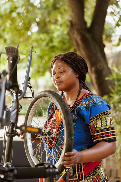 Odaklanmış Genç Bayan Bisikletçi Lastiği Sıkıca Güvenceye Alarak Motorun Açık — Stok fotoğraf