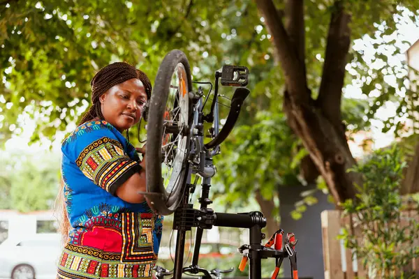 Skupiona Zdrowa Afroamerykanka Naprawiająca Rower Podwórku Przeprowadzająca Coroczną Konserwację Świeżym — Zdjęcie stockowe