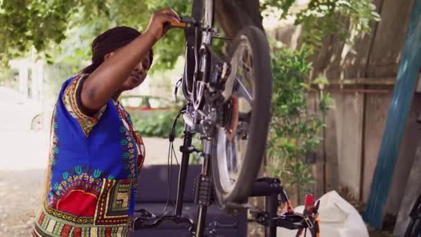 Odaklanmış Siyah Kadın Bileşenleri Dikkatlice Inceleyerek Modern Bisikleti Açık Hava — Stok video