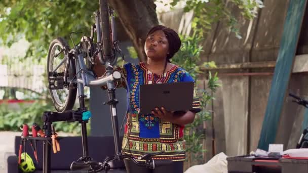 그녀의 노트북과 보수를 자전거에 정보를 헌신적인 스포츠 인터넷을 자전거를 아프리카계 — 비디오
