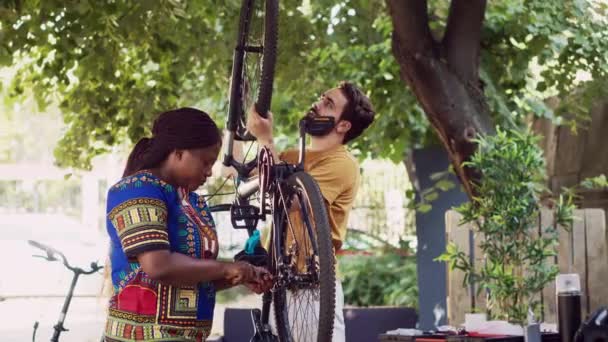Casal Multiétnico Comprometido Saudável Conversando Mantendo Componentes Bicicleta Homem Caucasiano — Vídeo de Stock