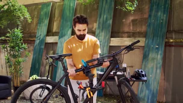 Junger Engagierter Mann Greift Und Bewegt Kaputtes Fahrrad Zum Reparaturstand — Stockvideo