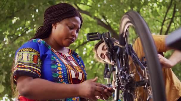 Active Multiethnic Couple Servicing Repairing Modern Bicycle Wheel Outdoor Caucasian — Stock Video