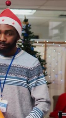 Afro-Amerikan iş arkadaşı şık spor ceketler getirirken, müşterilerine güzel kırmızı elbiseler gösteren, şenlikli alışveriş merkezi moda butiğindeki arkadaş canlısı perakende satış asistanı.