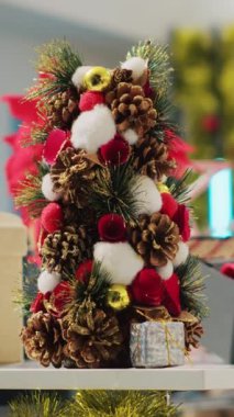 Dikey video, kış tatili sezonunda kıyafet mağazasında Noel süsleri çekiliyor. Moda butiğinde xmas süsleri, çelenkler ve resmi kıyafet gösterimi