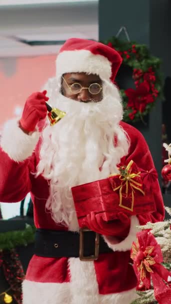 Вертикальное Видео Африканский Служащий Выдающий Себя Санта Клауса Звонит Колокола — стоковое видео