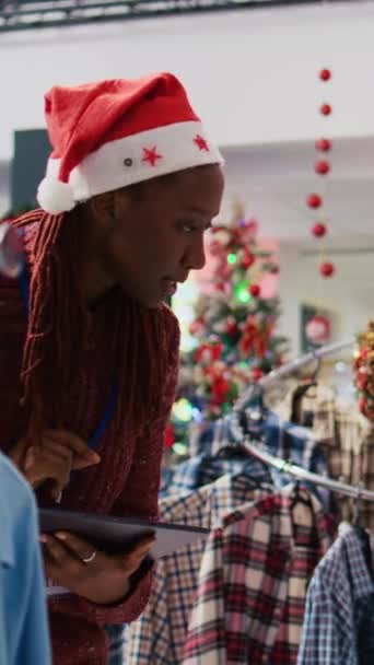Vertical Video African American Supervisor Wearing Santa Hat Browsing Clothes — Stock Video
