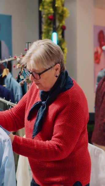 Вертикальне Відео Старша Жінка Яка Переглядає Стелажі Магазині Одягу Чоловіків — стокове відео
