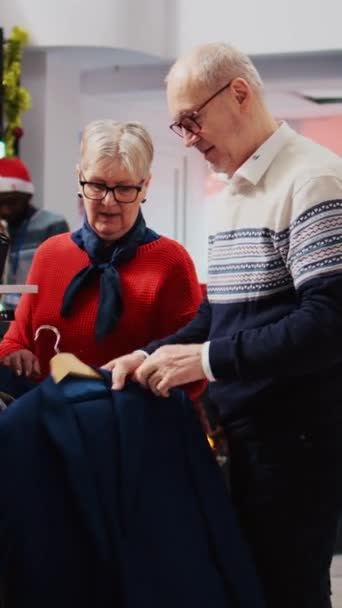 Vertikales Video Ein Älteres Ehepaar Stöbert Während Eines Weihnachtseinkaufs Kleiderständern — Stockvideo