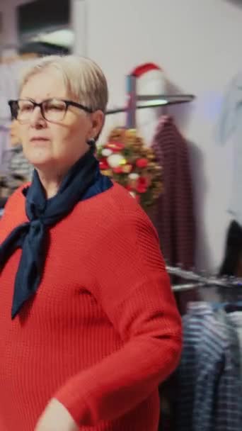 Κάθετη Βίντεο Ηλικιωμένοι Πελάτη Περιήγηση Μέσα Από Ρούχα Εορταστικά Χριστούγεννα — Αρχείο Βίντεο
