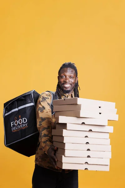 Paket Teslimat Sırasında Pizza Kutuları Taşıyan Neşeli Teslimatçı Sarı Arka — Stok fotoğraf