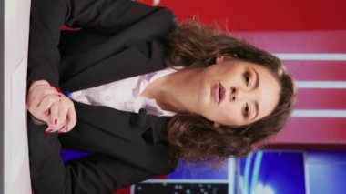 Vertical Video News spikeri haber odasındaki televizyon içeriği için küresel habercilikten bahsediyor, canlı TV programında haber sunuyor. Kadın medya sunucusu önemli günlük olayları yayınlıyor