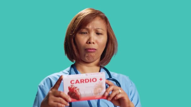 Hälso Och Sjukvårdspersonal Som Håller Miokardiska Tabletter Rutan Läsa Ingredienser — Stockvideo