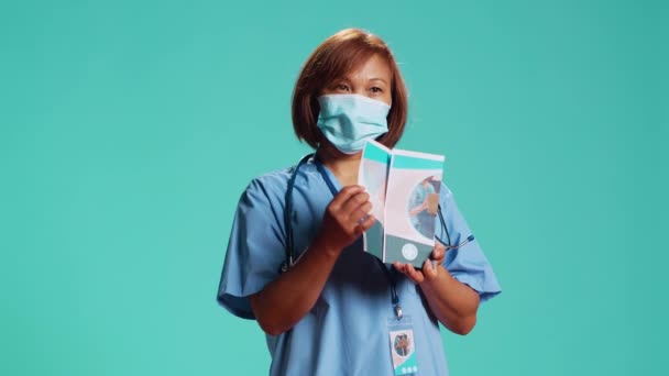 Deneyimli Hemşire Klinikteki Profesyonel Hizmetlerin Listesini Içeren Tıbbi Broşürü Sunuyor — Stok video