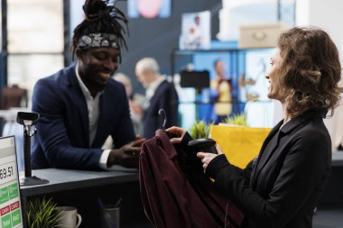 Yazarkasa müdürüyle konuşan şık bir müşteri alışveriş merkezindeki posizyon terminalinde işlem yapıyor. Mağaza tarayıcısı kullanarak butik çalışanının gömleğini taraması, ticari faaliyet.