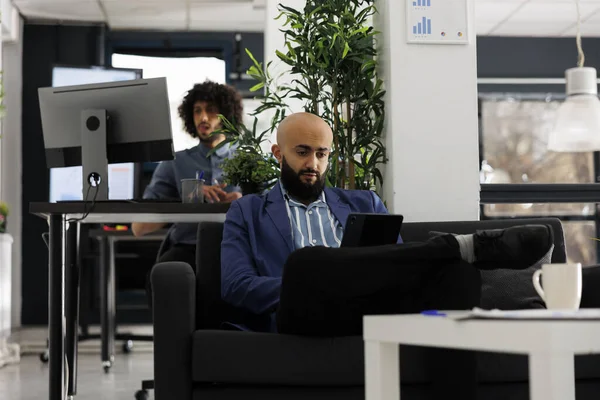 阿拉伯商人在合作空间分析数字平板电脑的财务数据 执行经理坐在沙发上 为公司办公室的业务发展项目工作 — 图库照片