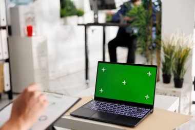 Şirket bütçesini planlayan ve krom ekranlı dizüstü bilgisayar kullanan bir yönetici. Girişimci satış ölçümlerini analiz ediyor ve yeşil ekranlı taşınabilir bilgisayar üzerinde çalışıyor