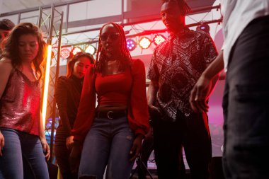 Arkadaşlar gece kulübünün partisinde dans savaşı yaparken. Genç ve çeşitli insanlar dans pistinde coşkulu spot ışıklarıyla eğleniyor ve kutlama yapıyorlar.