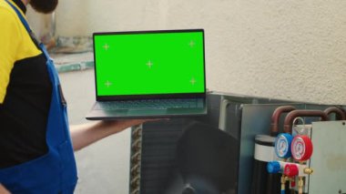 Deneyimli bir işçi, yeşil ekran dizüstü bilgisayarda arızalı yoğunlaştırıcı için yeni iç parçalar sipariş ediyor. Tecrübeli kablocu internetten klima yenileme bileşenleri arıyor.