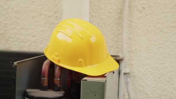 极近的黄色安全帽顶部出现故障 外部空调机需要维修 已开启的暖通空调系统上的专业防护工程装置 — 图库视频影像