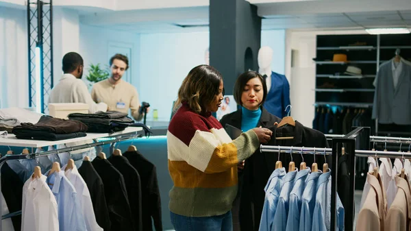 Азиатский Розничный Рабочий Помогает Клиенту Выбрать Одежду Используя Планшет Проверки — стоковое фото