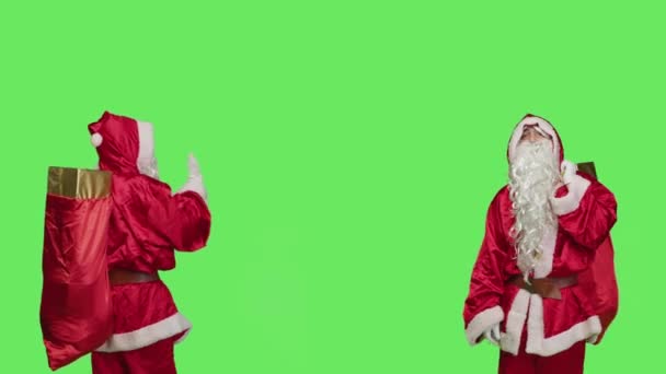 セントニックは 左側または右側にオブジェクトをプッシュし スタジオでグリーンレン上にジェスチャーを解雇することを示しています サンタクロースは拒絶サイン クリスマスイブのお祝いのコンセプトを行う実施 — ストック動画