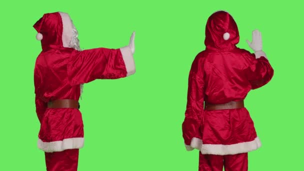 サンタのキャラクターは 緑色の背景でカメラの停止シンボルを表現するノーとしてパームを示しています 拒否ジェスチャー ホリデーシーズンのコンセプトを示す赤い衣装の聖なるニックのようなモデル — ストック動画
