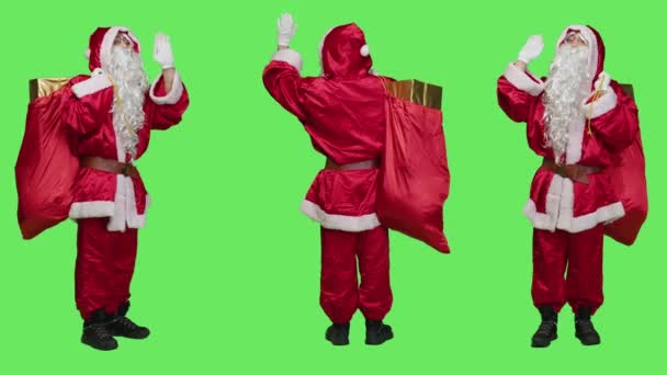 Babbo Natale Che Saluta Davanti Alla Telecamera Portando Sacco Pieno — Video Stock