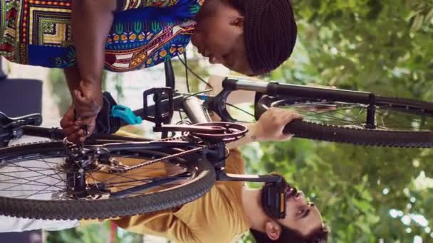 Vídeo Vertical Casal Multiétnico Comprometido Saudável Conversando Mantendo Componentes Bicicleta — Vídeo de Stock