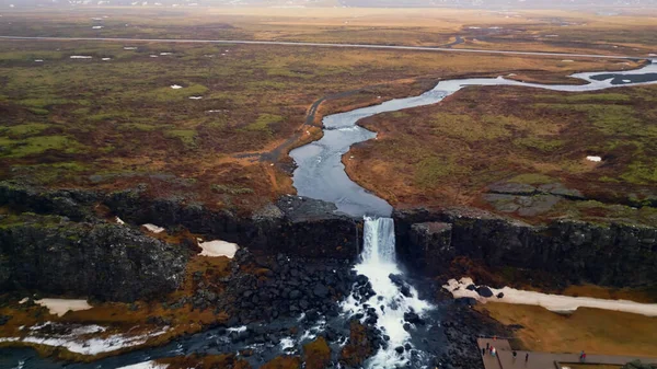 冰原上的草炭瀑布的无人机镜头 令人叹为观止的北方瀑布从山上滑落下来 造成了丑闻般的鸟类景观 美丽的冰岛河流淌下 — 图库照片