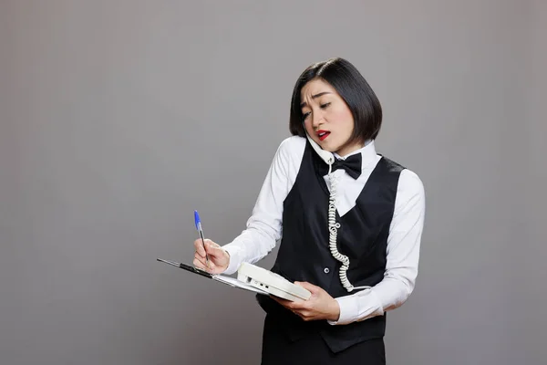 Aziatische Vrouw Receptioniste Controleren Van Informatie Klembord Tijdens Het Praten — Stockfoto