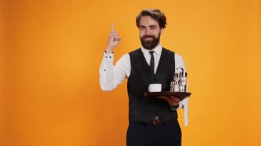 Stüdyoda nitelikli bir işçinin elinde yemek tepsisiyle dikilip işaret parmağını yukarı kaldıracak yeni bir fikri var. Restoran sektöründe insanlara hizmet etmek için çatal bıçak ve içecek taşıyan usta bir uşak..