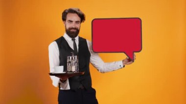 Yemek şirketi çalışanı stüdyodaki kırmızı simge kesiminde boş afiş ile konuşma balonu sunuyor. Bu da boş karton izole edilmiş bir kopya alan ile reklamı gösteriyor. Yemek tepsisi taşıyan genç uşak..