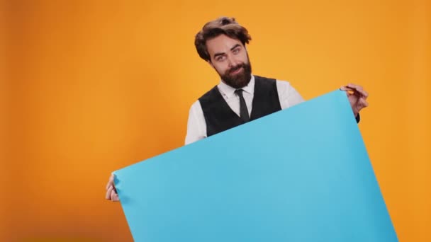 Wykwalifikowany Lokaj Trzymający Pusty Niebieski Sztandar Przed Kamerą Pokazujący Plakat — Wideo stockowe