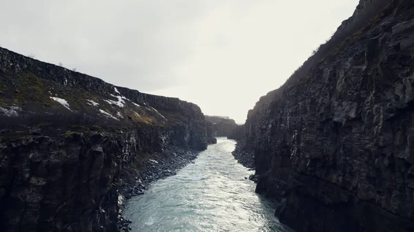 アイスランドのガルフフォスカスケード 岩の多い丘や崖の間を流れる壮大な水の流れのドローンショット 冬の風景をオフに実行しているアイスランドの美しい滝 スローモーション — ストック写真