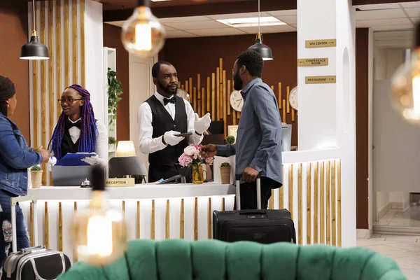Afroamerikansk Hotellreceptionist Som Talar Med Gästen Och Bekräftar Bokningsuppgifterna Personalen — Stockfoto