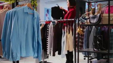 Dolly, kostüm mağazasındaki Asyalı müşterinin kış tatili sezonundaki Noel tanıtım satışlarından yararlanarak rahat elbiseler satın almaya çalışmasını çekiyor.