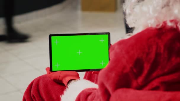 Mitarbeiter Weihnachtlich Geschmückten Bekleidungsgeschäft Verkleidet Als Weihnachtsmann Mit Grünem Bildschirmtablett — Stockvideo