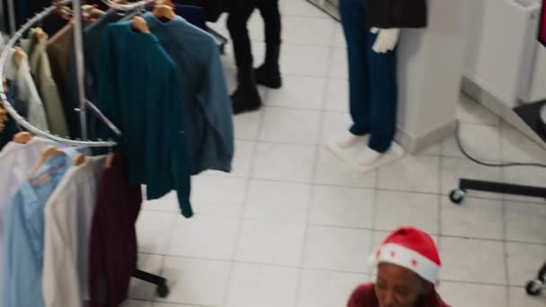 忙碌的服装店挤满了圣诞狂热的顾客 他们想给朋友和家人买些完美的礼物 寒假期间在商场精品店疯狂购物的顾客 — 图库视频影像