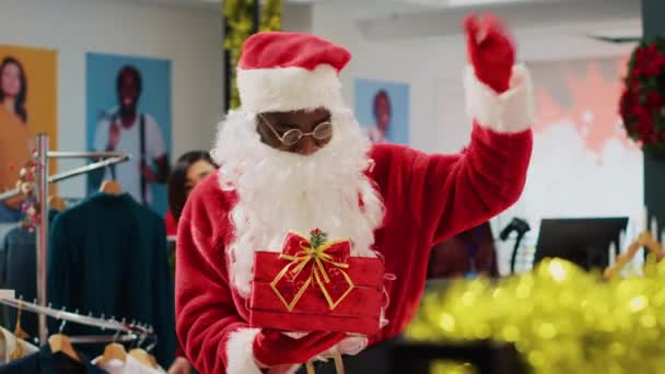 Работник Наряде Санта Клауса Богато Украшенном Магазине Одежды Приглашая Клиентов — стоковое видео