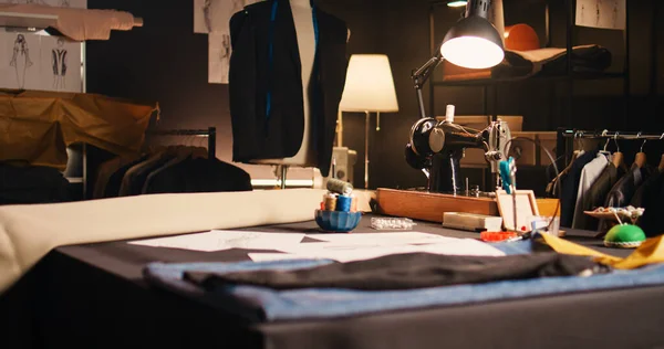 Professional atelier with tailor tools used for custom made tailored items to design fashion collection. Tailor workshop with sewing machines and garment for needlework, small business.