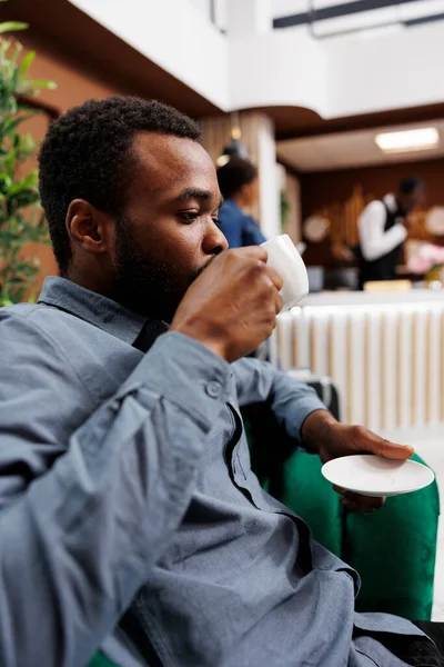 Afroameričan Hotelový Host Sedí Křesle Pije Kávu Odpočívá Hale Nebo — Stock fotografie