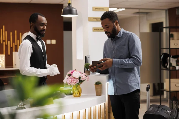 African American Guy Hotel Gäst Visar Sitt Pass Till Receptionist — Stockfoto