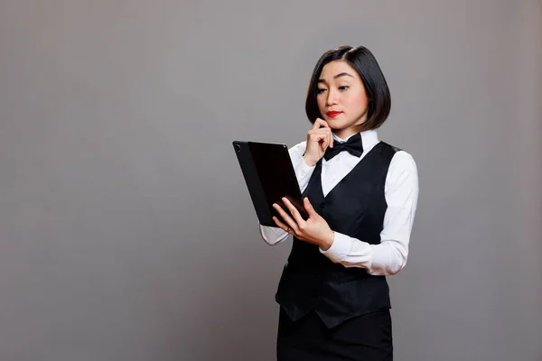 Thoughtful Asian Waitress Professional Uniform Managing Order Digital Tablet Pensive — Stock Photo, Image