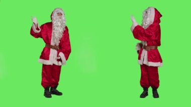 Noel arifesi kutlaması için pazarlama reklamı yapmak için beyaz sakallı Noel Baba, tatil ruhu. Genç adam yeşil ekranda reklam yapıyor..