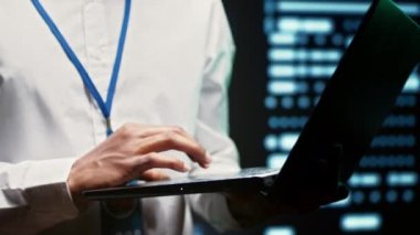 Veri merkezindeki mühendis, kuantum mekaniği ya da hava tahmini gibi hesaplama açısından yoğun görevler için kullanılan sunucu raflarında yürüyor. Rutin ekipman teşhisi konusunda uzman. Kapatın.