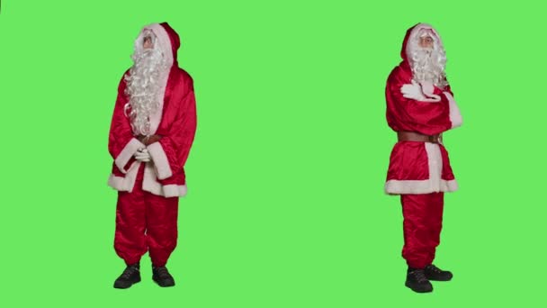 身穿桑塔服装的男人感到不耐烦 一边站在全身上下绿屏的背景上 一边等待着什么 圣尼克的角色在工作室里走来走去 圣诞节前夕 — 图库视频影像